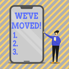 Writing note showing We Ve Moved. Business concept for having strong feelings sadness or sympathy has said or done Man Presenting Huge Smartphone while Holding Another Mobile