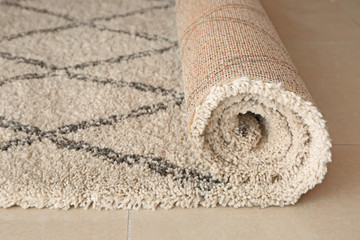 Fototapeta na wymiar Rolled carpet on floor in room