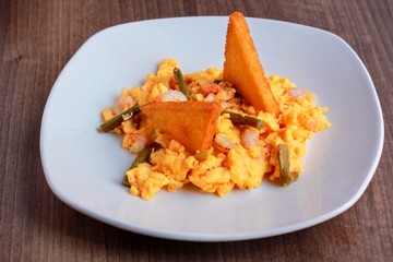 Huevos revueltos con esparragos gambas y patata rebozada
