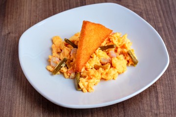 Huevos revueltos con esparragos gambas y patata rebozada