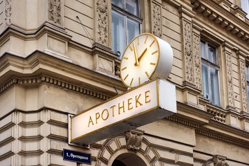 Austria, Vienna: Street scene with traditional old famous pharmacy with sign and clock on house facade in the city center of the Austrian capital - concept Aphotheke health illness. January 31, 2019