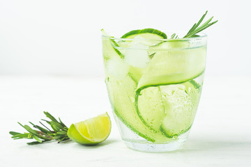 Drink from fresh cucumber juicy lime sprig of rosemary in a glass goblet on a white background. Summer refreshing detox.