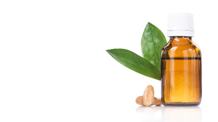 Bottle with liquid medicine, pills and green leaf isolated