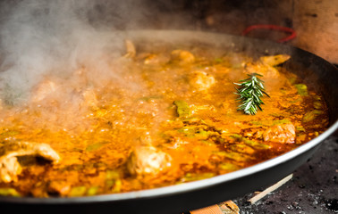 Cooking and making a traditional Spanish Paella over open fire.