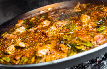 Cooking and making a traditional Spanish Paella over open fire.