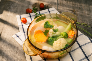 Assorted vegetables in glass pot on a napkin close up