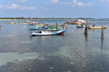 Fototapeta premium Traditional small fishing boats at the western side of Tanjung Kelayang Beach in Belitung Island, Indonesia