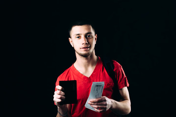 Man with air tickets and passport on a black background