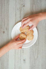 Two people taking cookies.  クッキーを取る2人