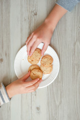 Two people taking cookies.  クッキーを取る2人