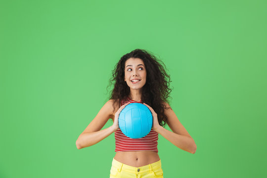 Image of energetic woman 20s wearing summer clothes smiling and holding volley ball