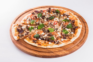 Pizza with mint on a wooden circular board isolated on white background