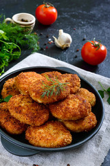 Juicy homemade cutlets (beef, pork, chicken) on a black background.