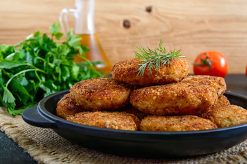 Juicy homemade cutlets (beef, pork, chicken) on a black background.