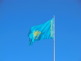 Fototapeta na wymiar Flag of Kazakhstan Republic over blue sky.