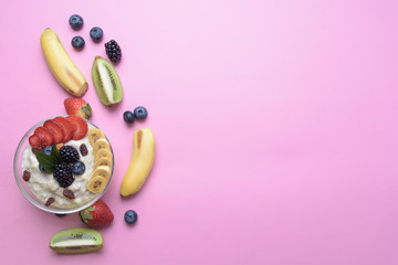 oatmeal with berries and fruits on pink background