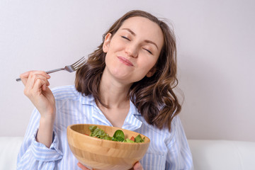 close up of woman eating healthy vegetable salad with pleasure