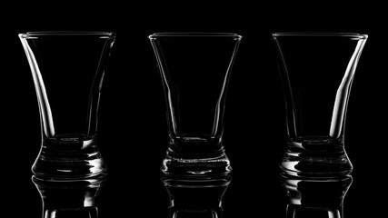 close up three empty shots on black background
