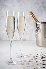 Two glasses of champagne with a champagne bottle in a bucket