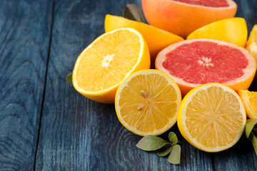 Fototapeta na wymiar Citrus fruit. Different citrus fruits with leaves of lemon, orange, grapefruit on a blue wooden table.
