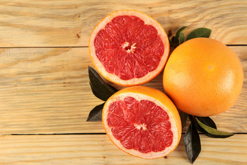 Citrus fruit. Fresh grapefruit with leaves on a natural wooden table. top view