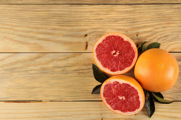 Fototapeta na wymiar Citrus fruit. Fresh grapefruit with leaves on a natural wooden table. top view. free space