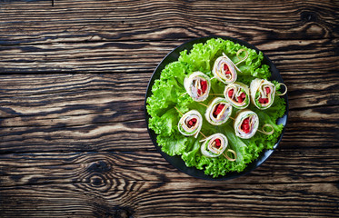 overhead view of sliced sandwich wraps on skewers