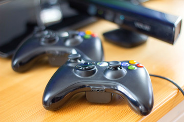 Close up black gaming controllers on wooden table, gamepad for video game at home