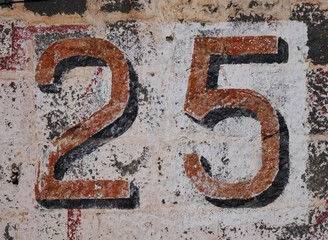 Number 25 lettering on old stone wall