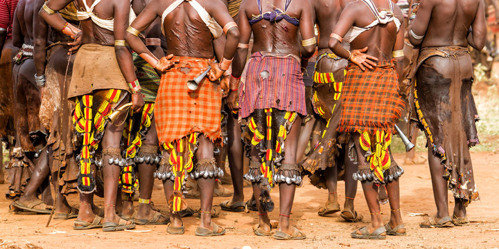 Hamar women in a village near Turmi during a bull jump ceremony.  their backs are full of scars from scourging during these ceremonies. It is a primitive tribe and the women have many decorations.