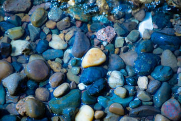 Sea stones in the sea water. Pebbles under water. The view from the top.