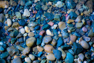 Sea stones in the sea water. Pebbles under water. The view from the top.