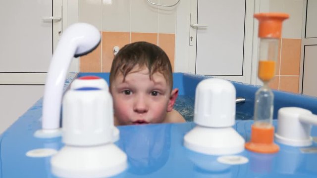 baby boy is taking a bath with bubbles. Jacuzzi bubble bath procedure.
