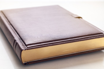 The book with a hard cover and leather cover on a white background.