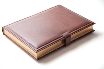 The book with a hard cover and leather cover on a white background.