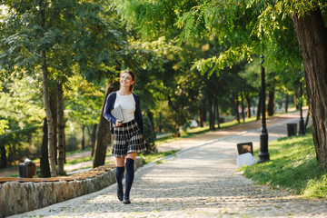 Cheerful young school girl walking outdoors