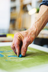 Artist makes the first srihi on canvas in the process of drawing with pastel crayons.