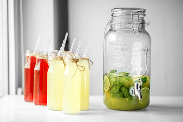 A lot of bottles of lemonade. Big can with tap for drinks. Concept of drinks, summer, bar, rest healthy food.