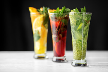 An assortment of refreshing cocktails with lime, lemon and orange and mint. Concept for drinks, summer, heat, alcohol, party and bar