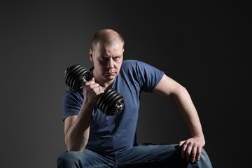 Obraz na płótnie Canvas Young male dumbbell in his hands