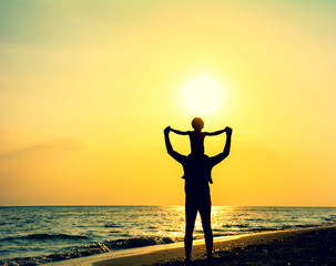 Silhouette of father and son enjoying sunset and life