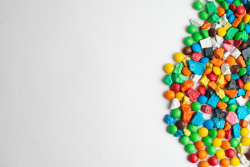 Colorful frame of multicolored candies on white background