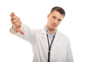 Portrait of young handsome doctor showing dislike gesture