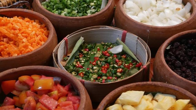 Top view of selection of various platters with delicious asian food and spices on a street market stall in Bangkok, Thailand