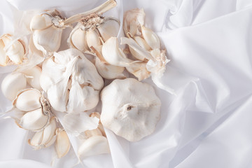 Obraz na płótnie Canvas Bulbs and garlic cloves on white textile.