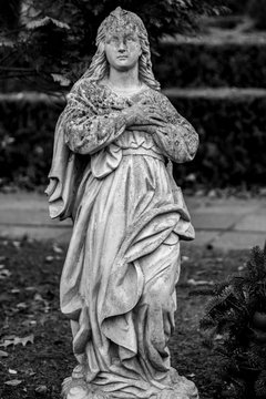 Alte verwitterte Statue einer Frauauf einem Grab auf einem Friedhof in Berlin Hermsdorf