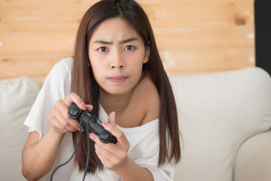 excited woman playing console video game. portrait of excited and fun asian woman plaing vdo game. hobby, liesure activity concept. asian young adult woman model
