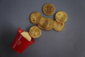 Red pile with golden replica of bitcoin on dark vignette grey background. © MohamadFaizal