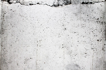 Alte weiße poröse Betonmauer mit Rissen