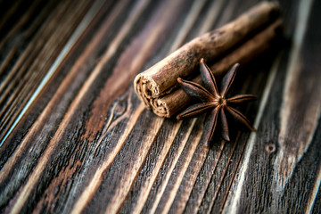 Cinnamon sticks and star anise on a wooden surface.
